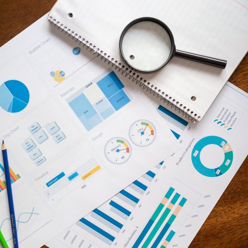 Photo by RDNE Stock project A set of financial charts and graphs with a magnifying glass, perfect for business reports.