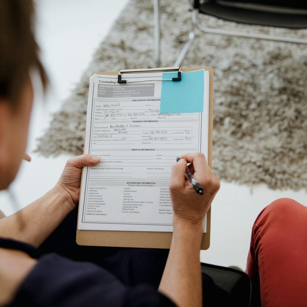 Photo by RDNE Stock project An adult woman writing on a counseling form during a business appointment in an office setting.